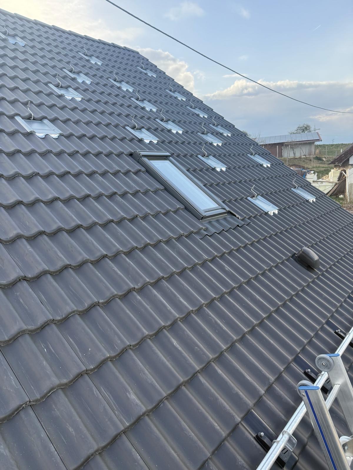 Graues Ziegeldach mit Dachhaken und Dachfenster